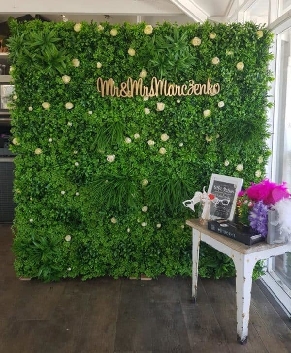 Lush green flower wall and rustic table