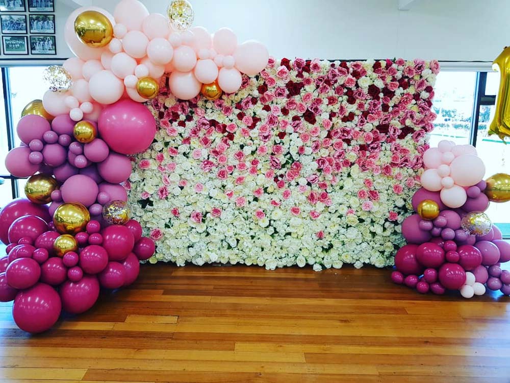 balloons styling around white and pink flower wall