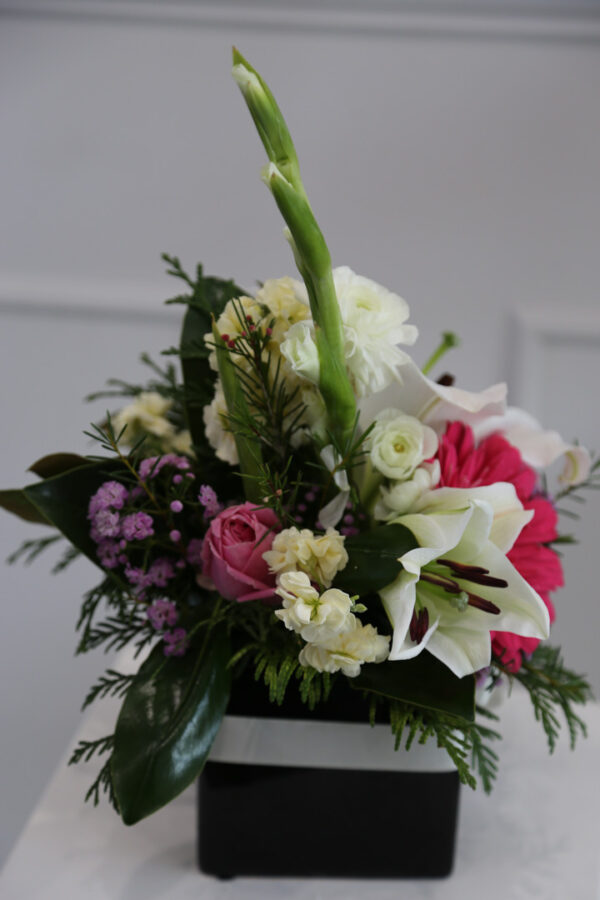Oriental lilies in a ceramic vase with mixed flowers