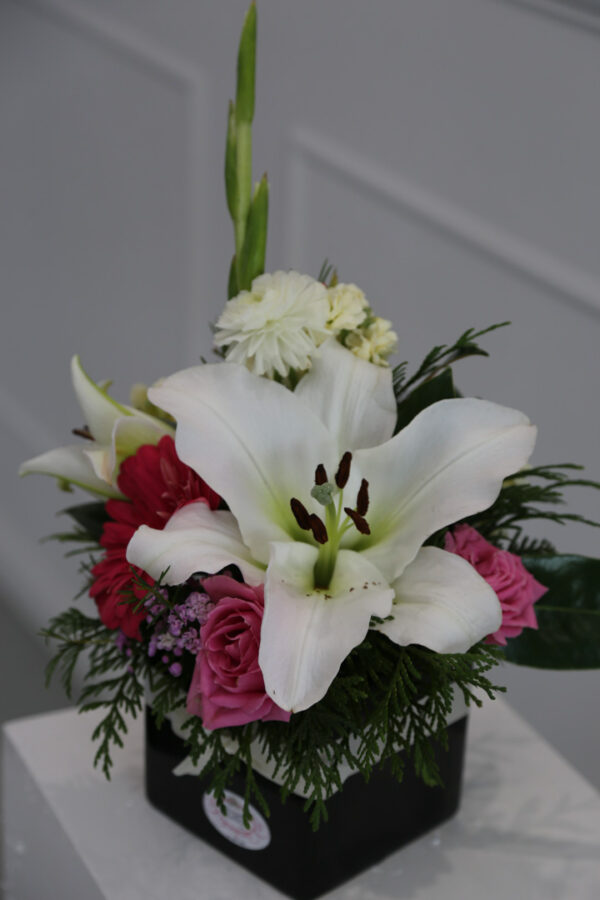 Oriental lilies in a ceramic vase with mixed flowers