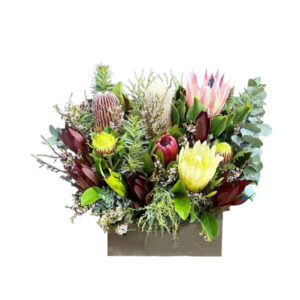 Beautiful fresh blooms arranged in a wooden trough. This beautiful arrangement includes a selection of quality traditional cut flowers that includes roses, lisianthus
