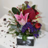 Natives and lilies with various seasonal flowers in a ceramic vase